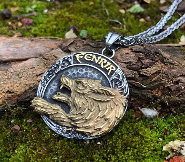 Gros plan du pendentif Fenrir tête de loup dorée, inscription Fenrir et motifs nordiques en relief