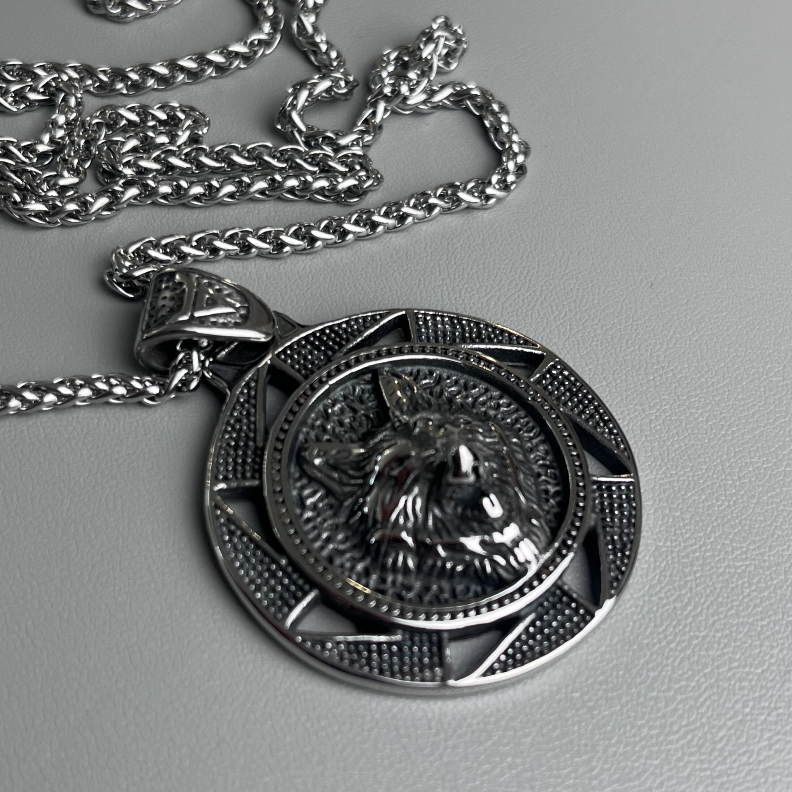 Vue inclinée du collier Viking Fenrir montrant la tête de loup sculptée et les reliefs argentés